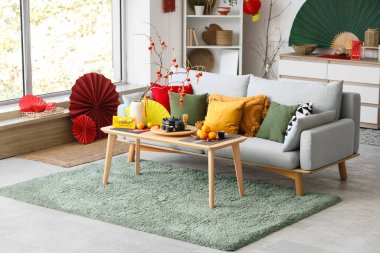 Çin Yeni Yıl kutlamaları için kanepe, masa ve dekorla aydınlık oturma odasının içinde.