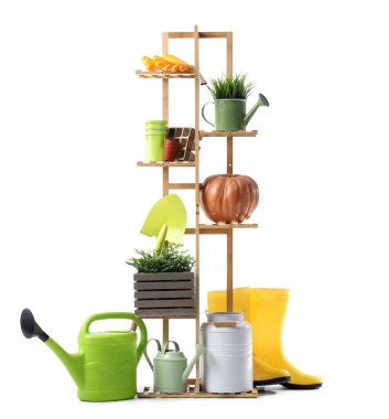 Beyaz arka planda bitki ve bahçe malzemeleri olan raf ünitesi.