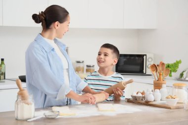 Genç anne ve oğlu mutfakta hamur topluyor.