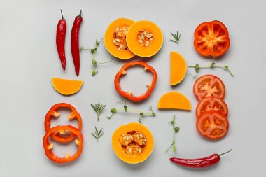 Gri arka planda taze sebzeler ve bitkilerle yakın plan kompozisyonu.