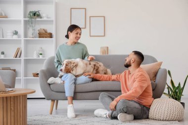 Avustralya çoban köpeği olan genç çift evde dinleniyor.