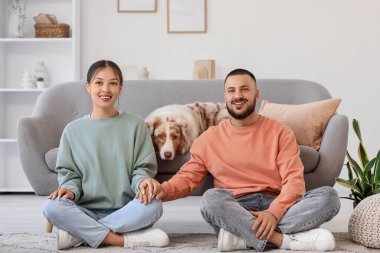 Avustralya çoban köpeği olan genç çift evde oturuyor.