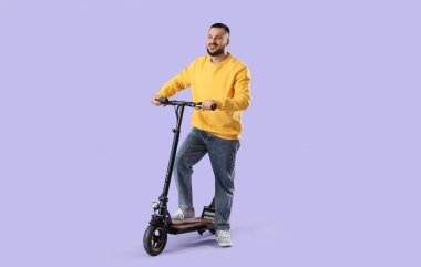 Leylak arka planında elektrikli scooter kullanan genç bir adam.