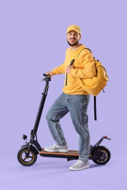 Leylak arka planında elektrikli scooter ve sırt çantası olan genç bir adam.