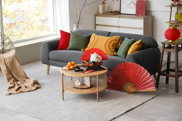 Çin Yeni Yıl kutlamaları için kanepe, masa ve dekorla aydınlık oturma odasının içinde.