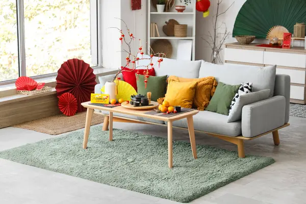 Çin Yeni Yıl kutlamaları için kanepe, masa ve dekorla aydınlık oturma odasının içinde.