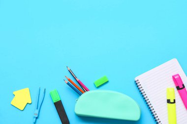 Mavi arka planda kırtasiye malzemesi olan kalem kutusu. Üst görünüm