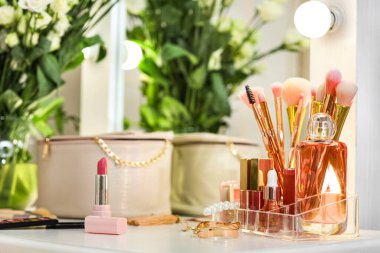 Giyinme odasındaki masada çiçekli dekoratif kozmetik ürünleri.