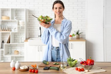 Mutfakta cam kâse taze sebze salatası olan güzel bir kadın.