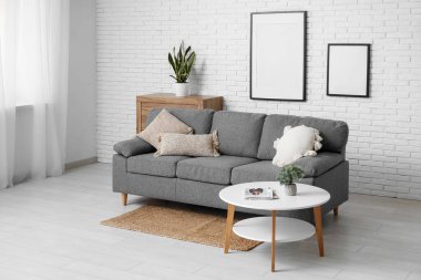 Gri kanepesi ve masası olan modern oturma odası.