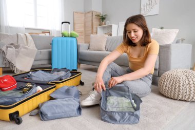 Genç bir kadın, kıyafetlerini evdeki ajandaya yerleştiriyor. Seyahat kavramı