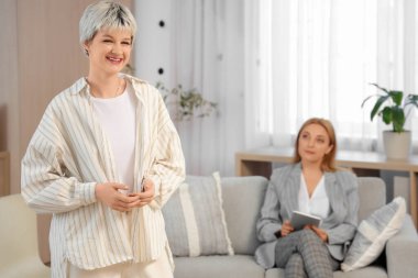 Genç kız psikologun ofisinde gülümsüyor.