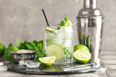 Bir bardak taze mojito kokteyli. Limonlu ve sallanan gri fayanslı.
