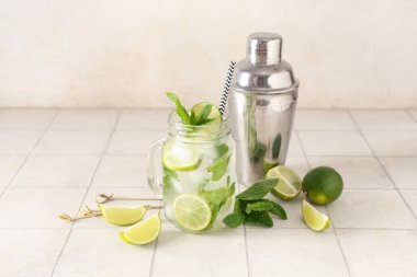 Mason kavanozu taze mojito kokteyli, limonlu ve sallanan beyaz fayanslı.