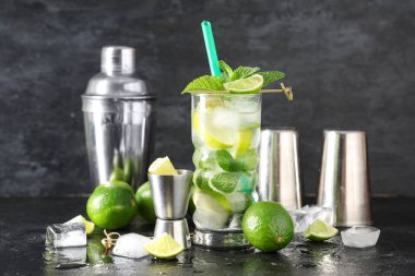 Siyah arka planda limonlu ve sallanan taze mojito kokteyli.