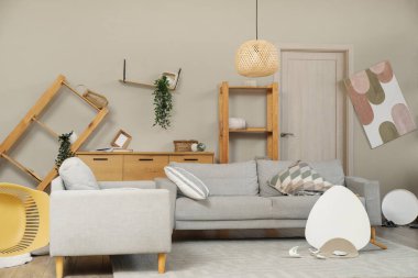 Depremden sonra mobilyaların devrildiği dağınık bir oturma odası.