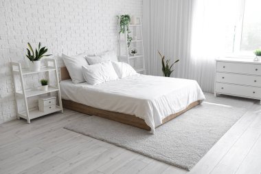 Rahat yatağı ve raf üniteleri olan modern yatak odası.