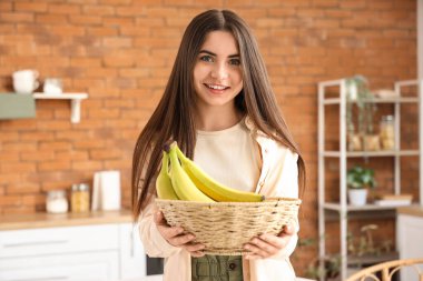 Mutfakta bir kase muzlu genç kadın.