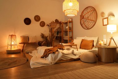 Şık bir yatak odası, rahat bir yatak odası, tepsi masası ve akşam lambaları.