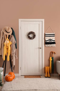 Koridorun içinde kapı, askılık ve şemsiyeler var.