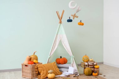 Çocuk odasının içinde oyun çadırı ve balkabağı var.