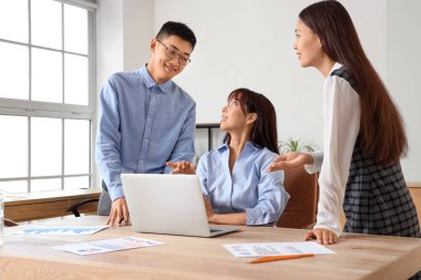 Ofiste dizüstü bilgisayarla çalışan Çinli işadamları.