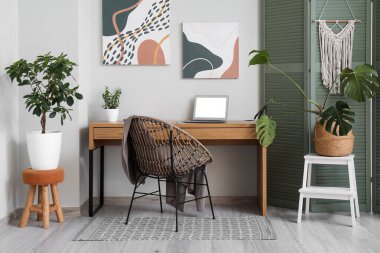 Şık bir oturma odasının içinde işyeri, koltuk ve katlanan ekran.