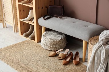 Koridorun içinde kadın ayakkabıları, yumuşak bank ve raf ünitesi var.