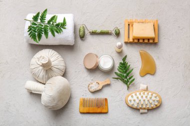 Masaj poşetleri, havlu, kavanoz ve beyaz grunge arka planda kozmetik ürünleri içeren spa kompozisyonu, yakın plan.