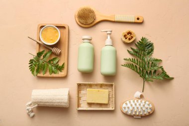 Tepsi, masaj vücut fırçası ve bej arka planda kozmetik ürünleri içeren spa kompozisyonu