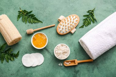 Masaj vücut fırçası, havlu, bal ve deniz tuzu ile kaplıca kompozisyonu yeşil grunge arka plan, yakın çekim
