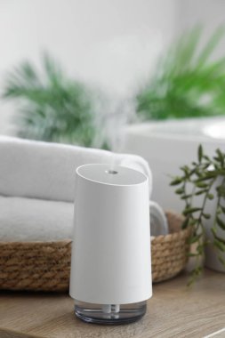 Hava nemlendirici ve havlular banyodaki masada, yakın plan.