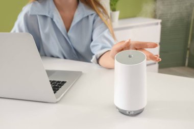 Ofisteki masasında hava nemlendiricisi olan kadın, yakın plan.