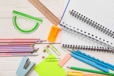 Beyaz ahşap arka planda farklı bir kırtasiye malzemesi. Üst görünüm