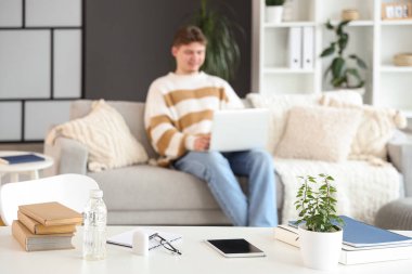 Erkek öğrencilerin evdeki masada internetten ders çalışmaları, yakın çekim.