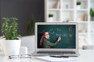 Öğretmen odada dizüstü bilgisayar ekranında matematik dersi veriyor, yakın plan.