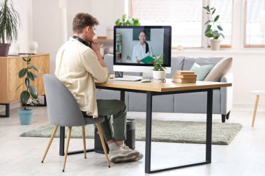 Erkek öğrenci evde internet öğretmeniyle çalışıyor.