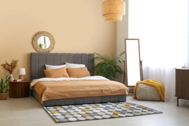 Sıcak yatak, ayna ve lamba güzel yatak odasındaki komodinin üzerinde.