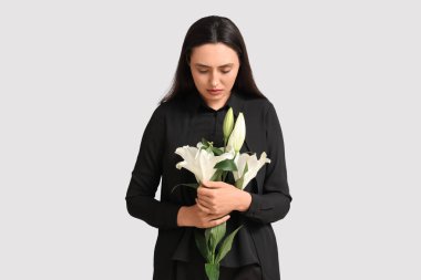 Beyaz arka planda bir buket nilüfer çiçeği olan genç bir kadın.