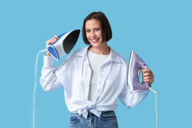 Mavi arka planda demirleri olan genç bir kadın.