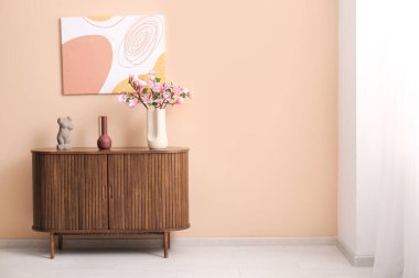 Üzerinde güzel manolya çiçekleri olan bir vazo şık oturma odasındaki çekmeceler.