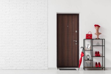 Koridorun içinde kapısı, raf ünitesi ve şemsiyesi var.