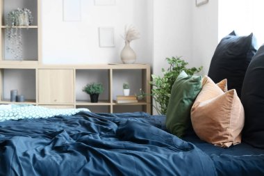 Modern yatak odasında siyah çarşaflı rahat bir yatak, yakın çekim.