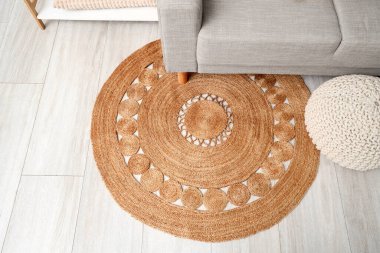 Salondaki hasır halıda gri kanepe, üst manzara.