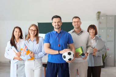 Okulda gülümseyen bir grup öğretmen.