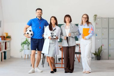 Okulda gülümseyen bir grup öğretmen.