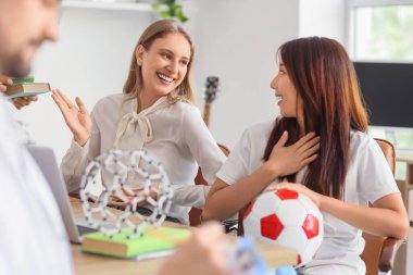 Okul ofisindeki masada bayan öğretmenler