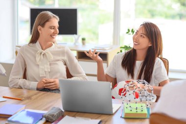 Okul ofisindeki masada bayan öğretmenler