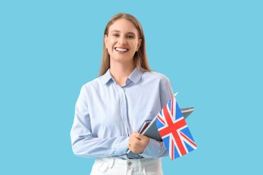 İngiliz bayrağı ve mavi arkaplan üzerine not defterleri olan İngilizce öğretmeni.