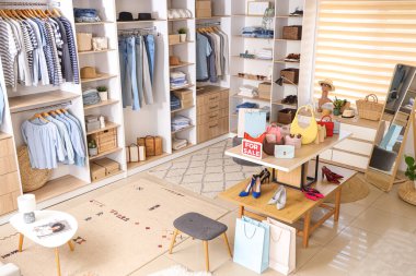 Şık giyimli, aksesuarlı ve aynalı butiğin içi.